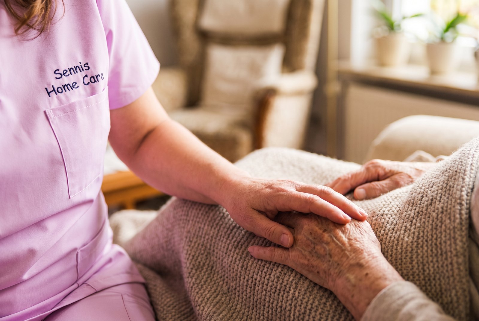 Hand der Pflegekraft auf der Hand einer älteren Dame